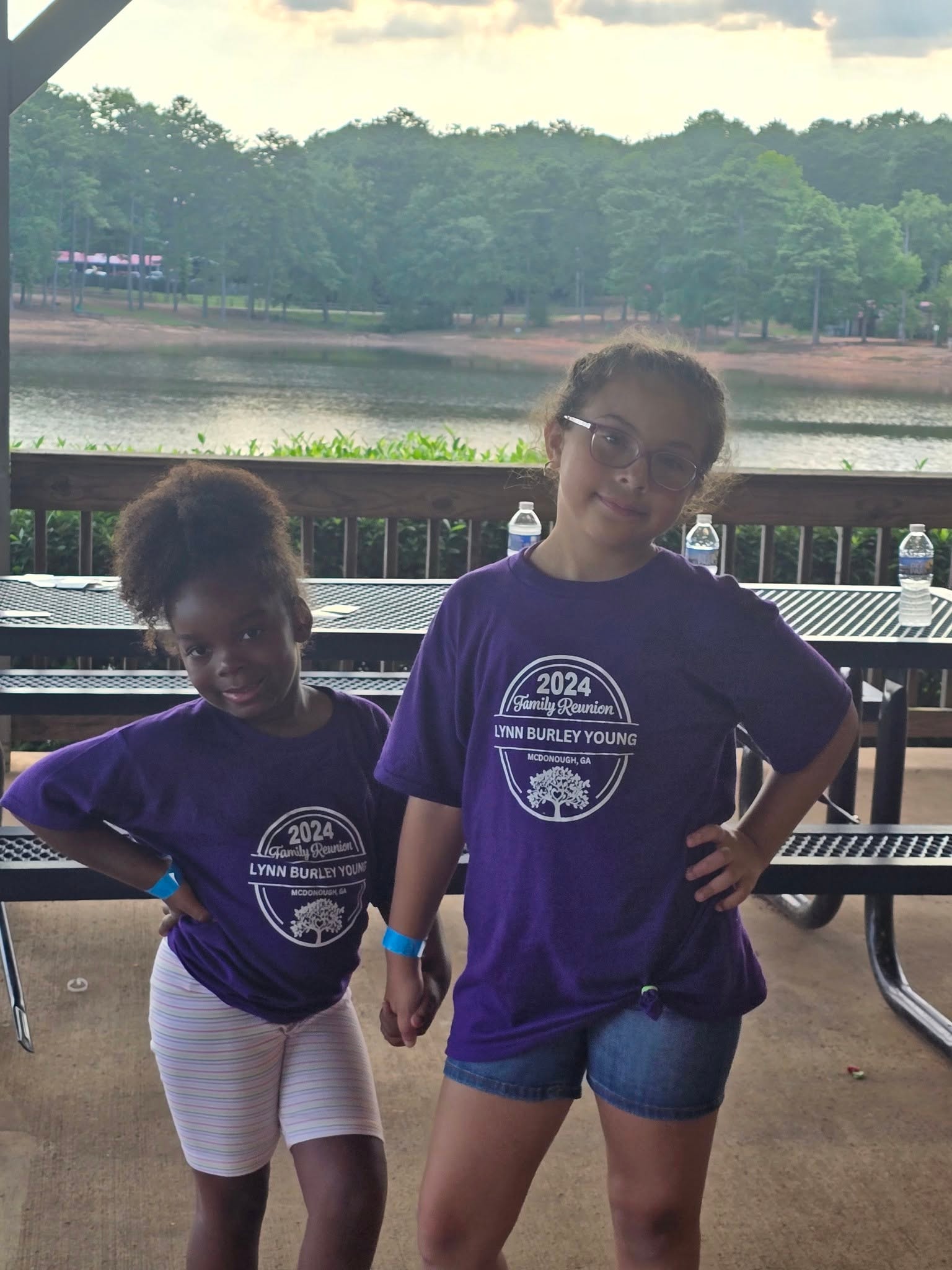 Two young girls in purple reunion shirts by the lake