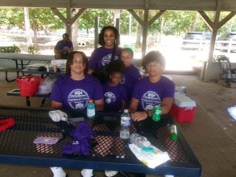 Two kids hugging in purple reunion shirts at pavilion