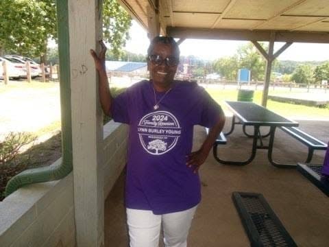 Woman smiling at reunion cookout pavilion picnic table